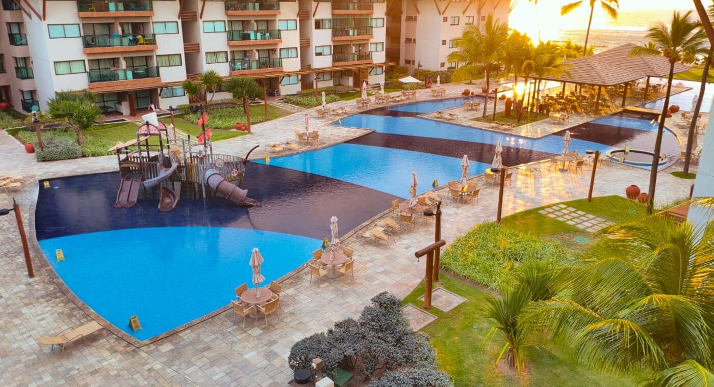 Piscinas e jardins do Polinésia Resort ao fim da tarde, vistos da varanda