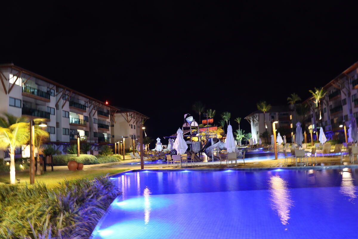 Piscina do Polinésia Resort iluminada ao anoitecer